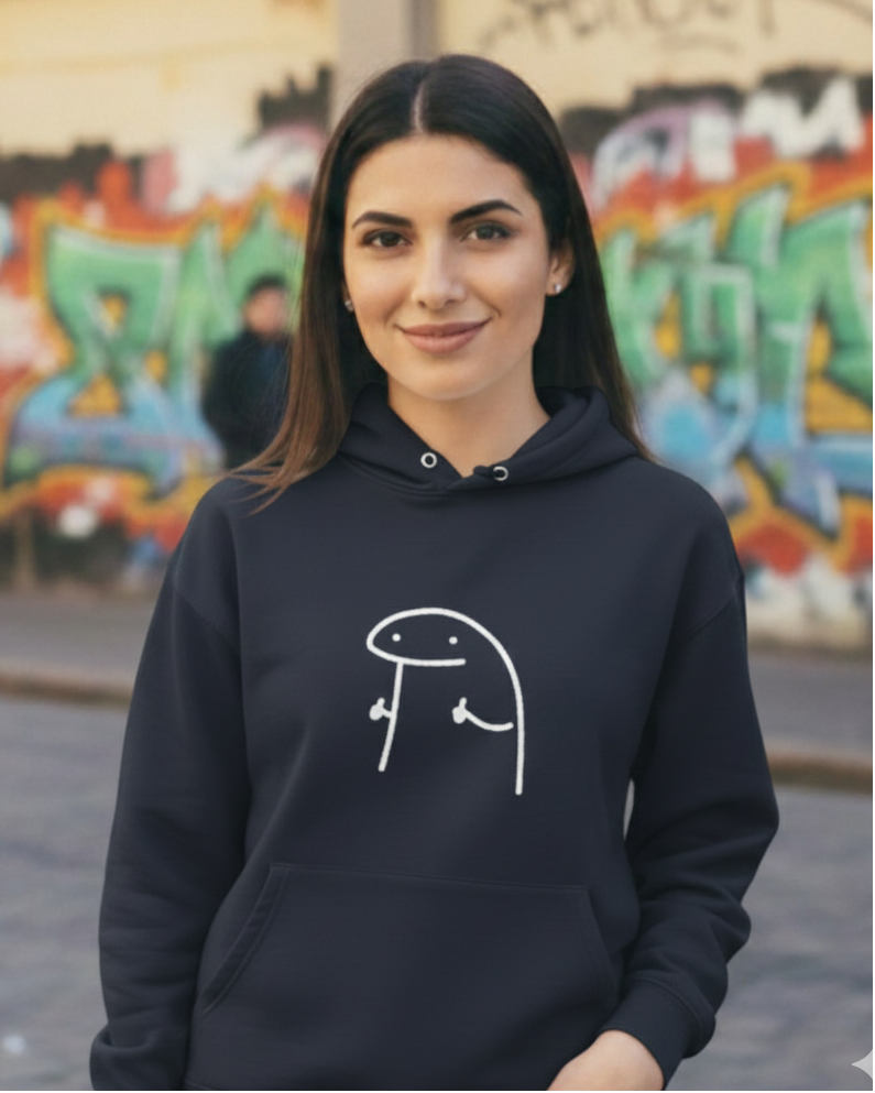 Person wearing a black hoodie with a white graphic design in front of graffiti art.