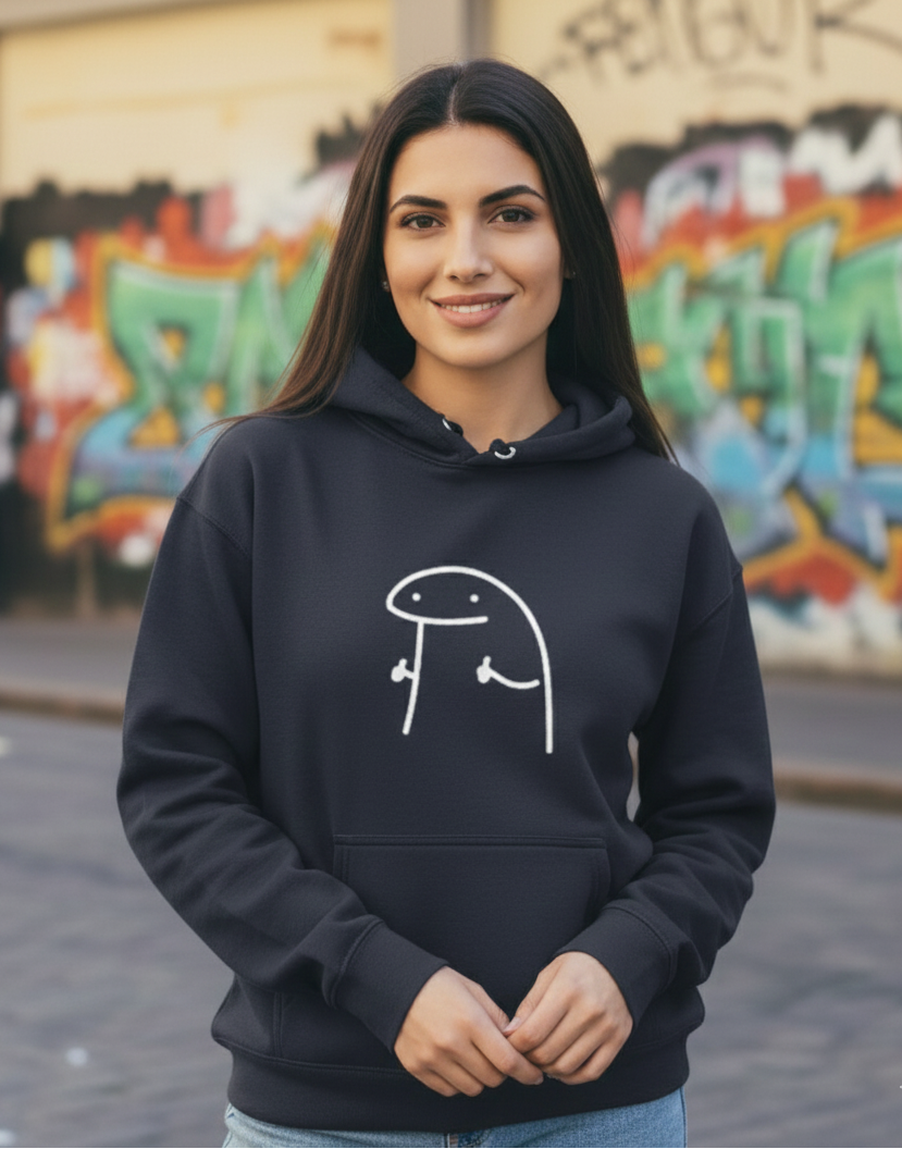 Woman wearing a black hoodie with a white graphic design in front of a graffiti-covered wall.